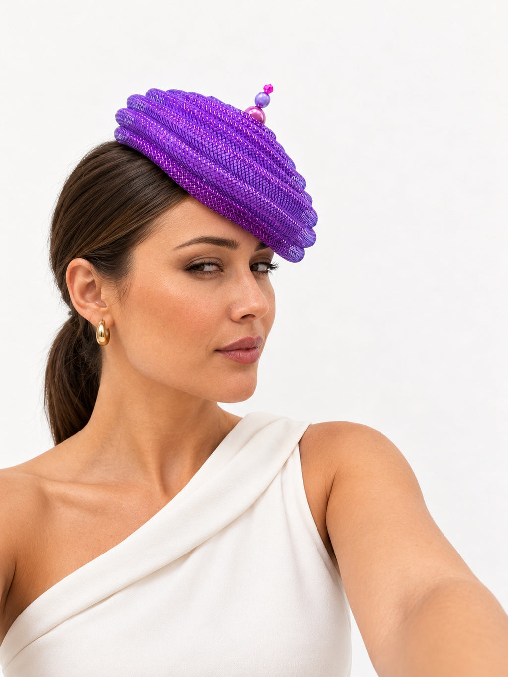 Onda Azzurra magenta spiral pillbox fascinator worn by a model, side view