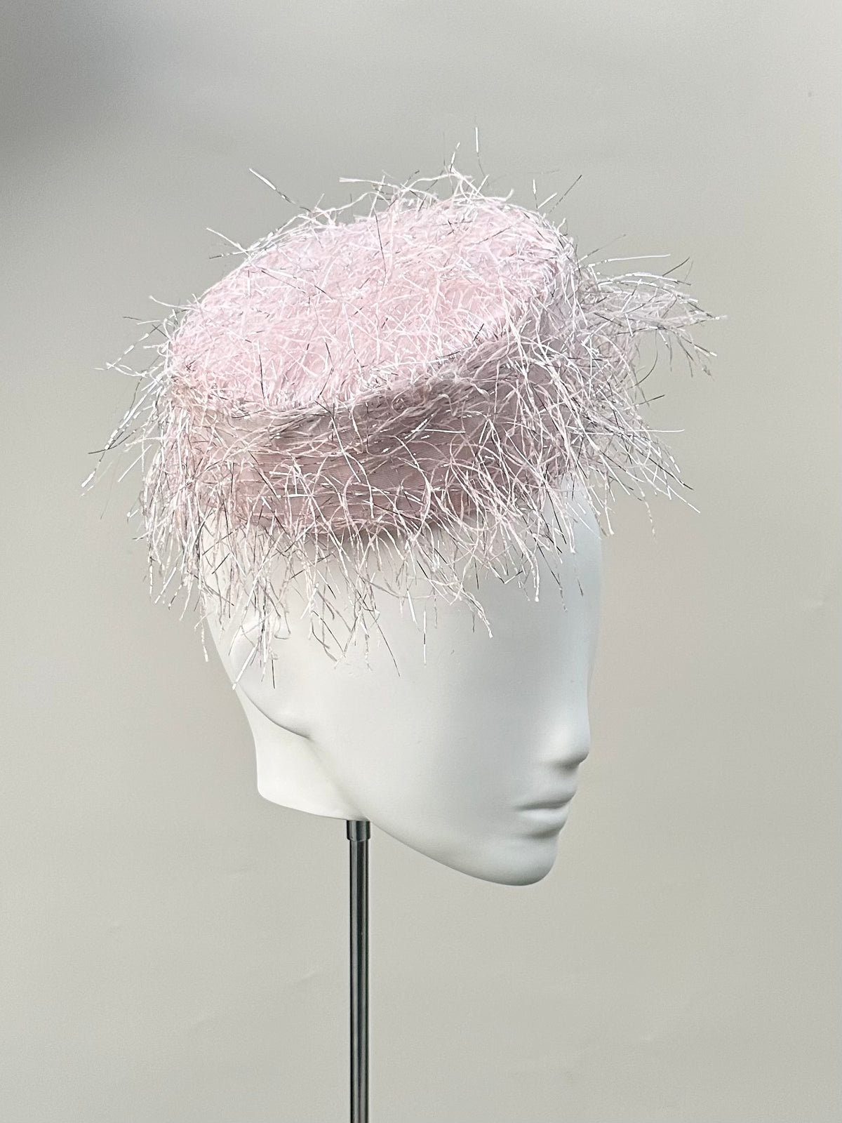 Frange di Luce blush pink pillbox hat with an angled silhouette and silver Lurex highlights