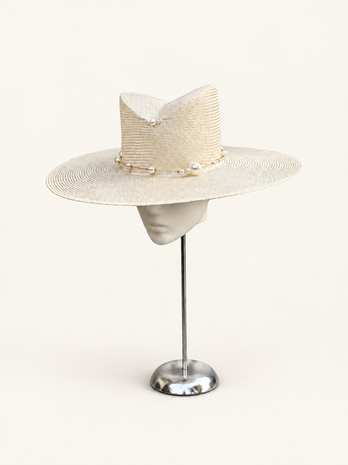 Bianco di Navagio ivory pearl wide-brim hat on a warm ivory studio background